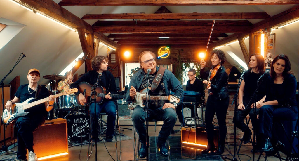 Ewald Pfleger mit Gitarre und seinen musikalischen Gästen beim Wohnzimmerkonzert