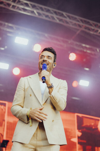 Giovanni Zarrella singt bei einem Live-Auftritt mit einem blauen Mikrofon.