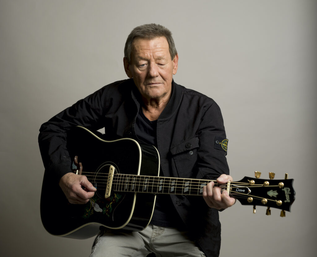 Wolfgang Ambros mit schwarzer Gitarre bei einem Portraitfoto